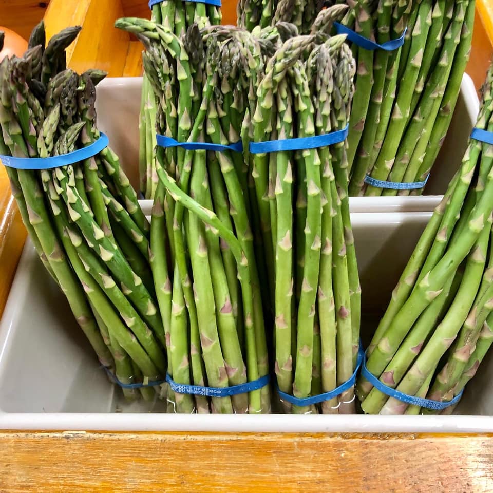A bunch of green asparagus with blue bands around them