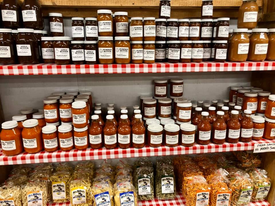 A store shelf filled with jars of sauces and pasta