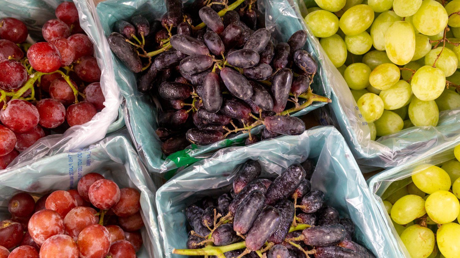 There are many different types of grapes in the baskets.