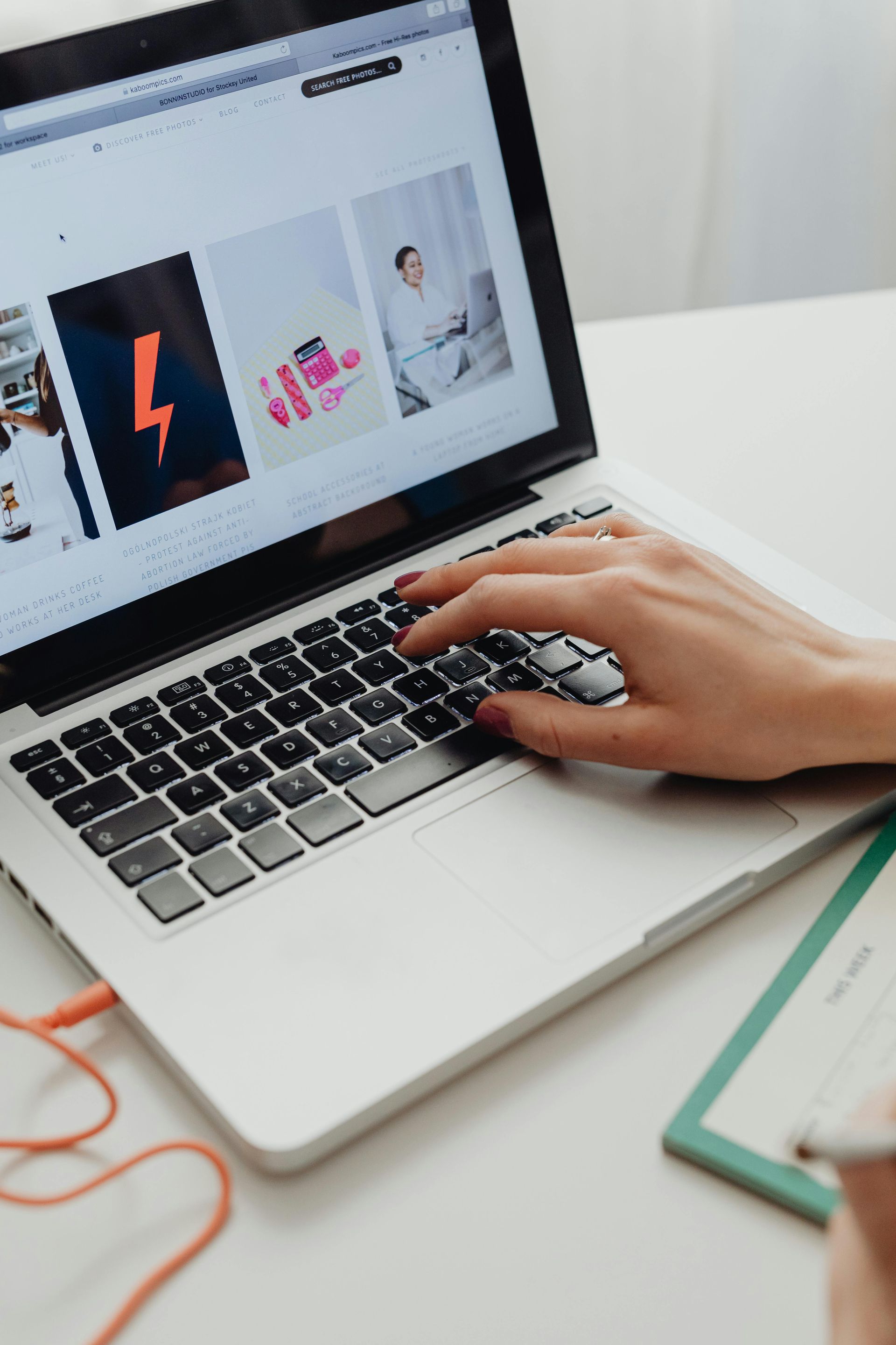A person is typing on a laptop with a lightning bolt on the screen.