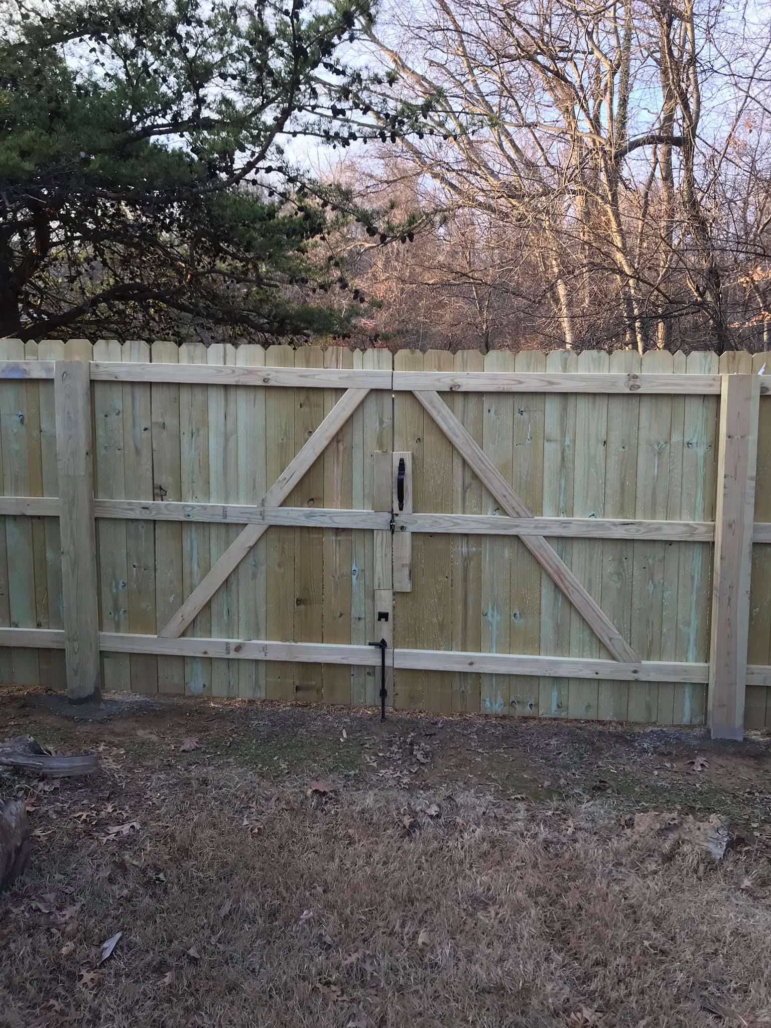A wooden fence with a gate in the backyard.