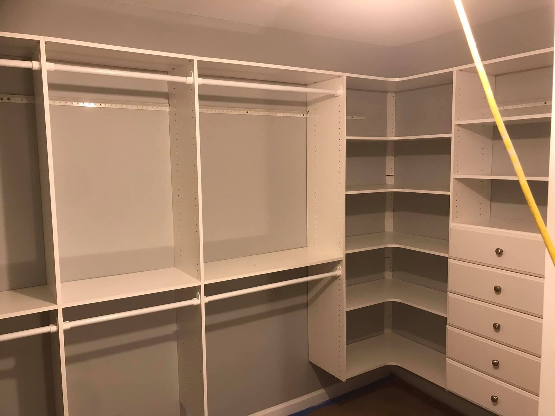 A walk in closet with lots of shelves and drawers