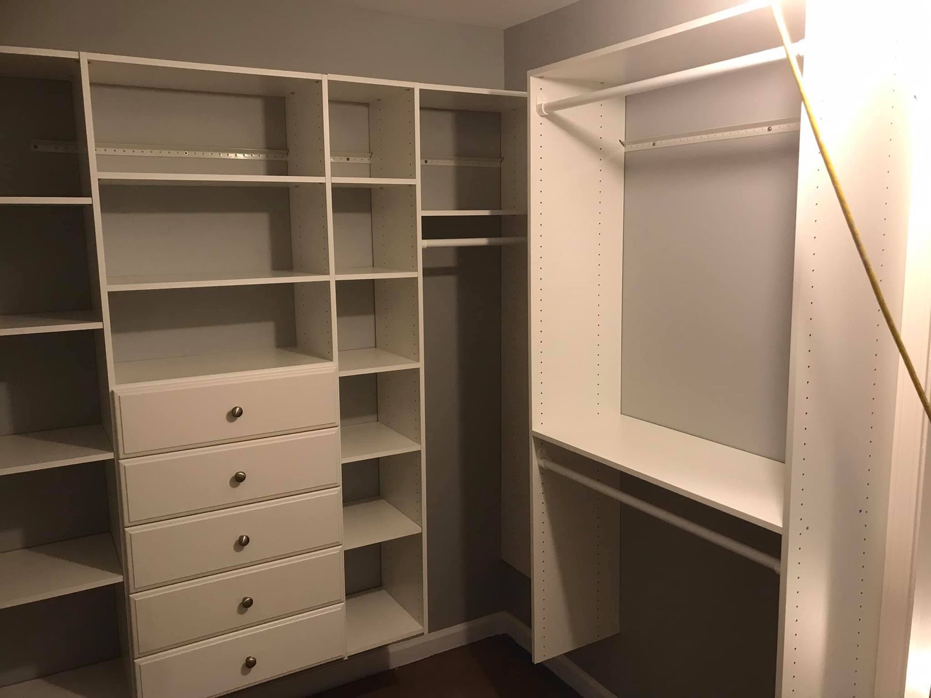 A walk in closet with lots of shelves and drawers.