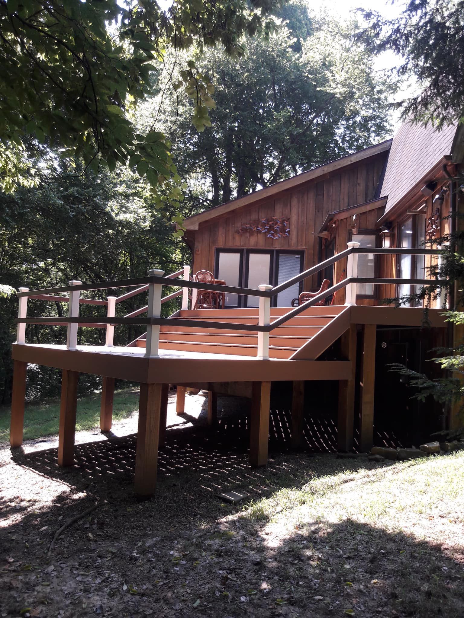 A wooden house with a wooden deck in front of it