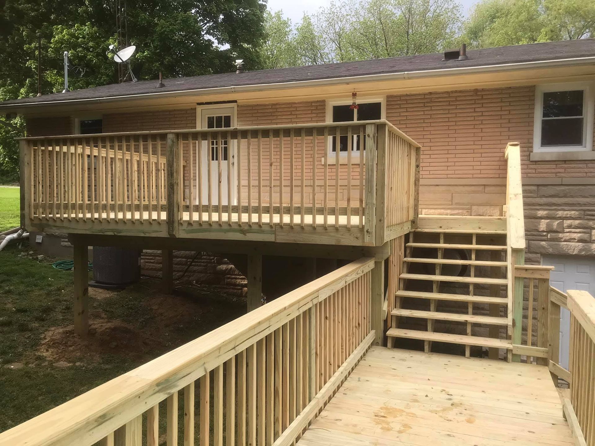 A house with a wooden deck and stairs leading to it.