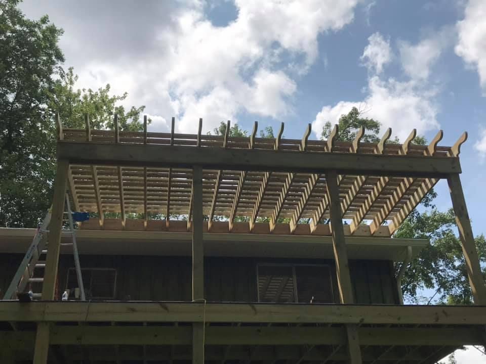 A wooden deck is being built on top of a house.