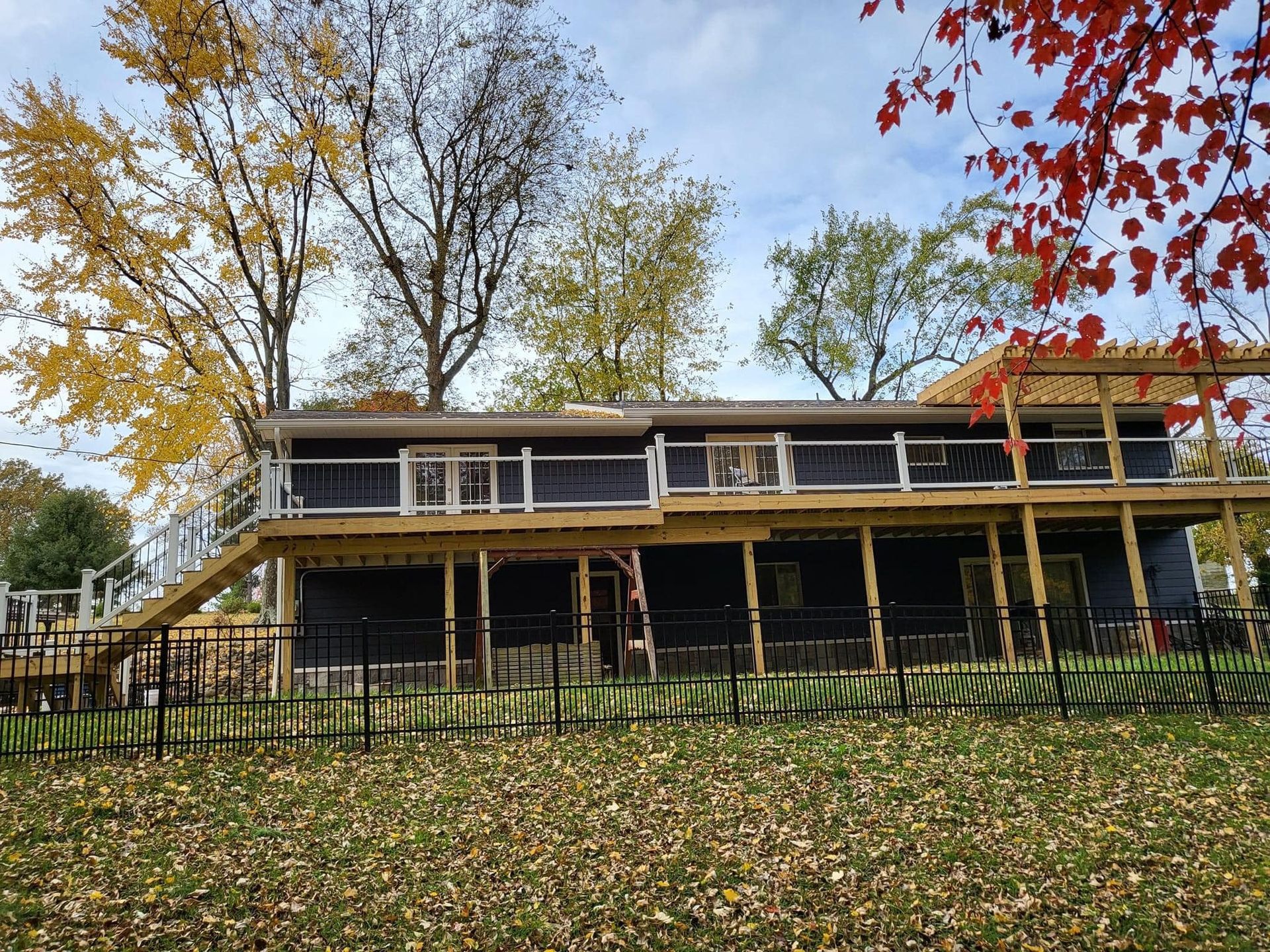 A large house with a large deck and a fence around it.