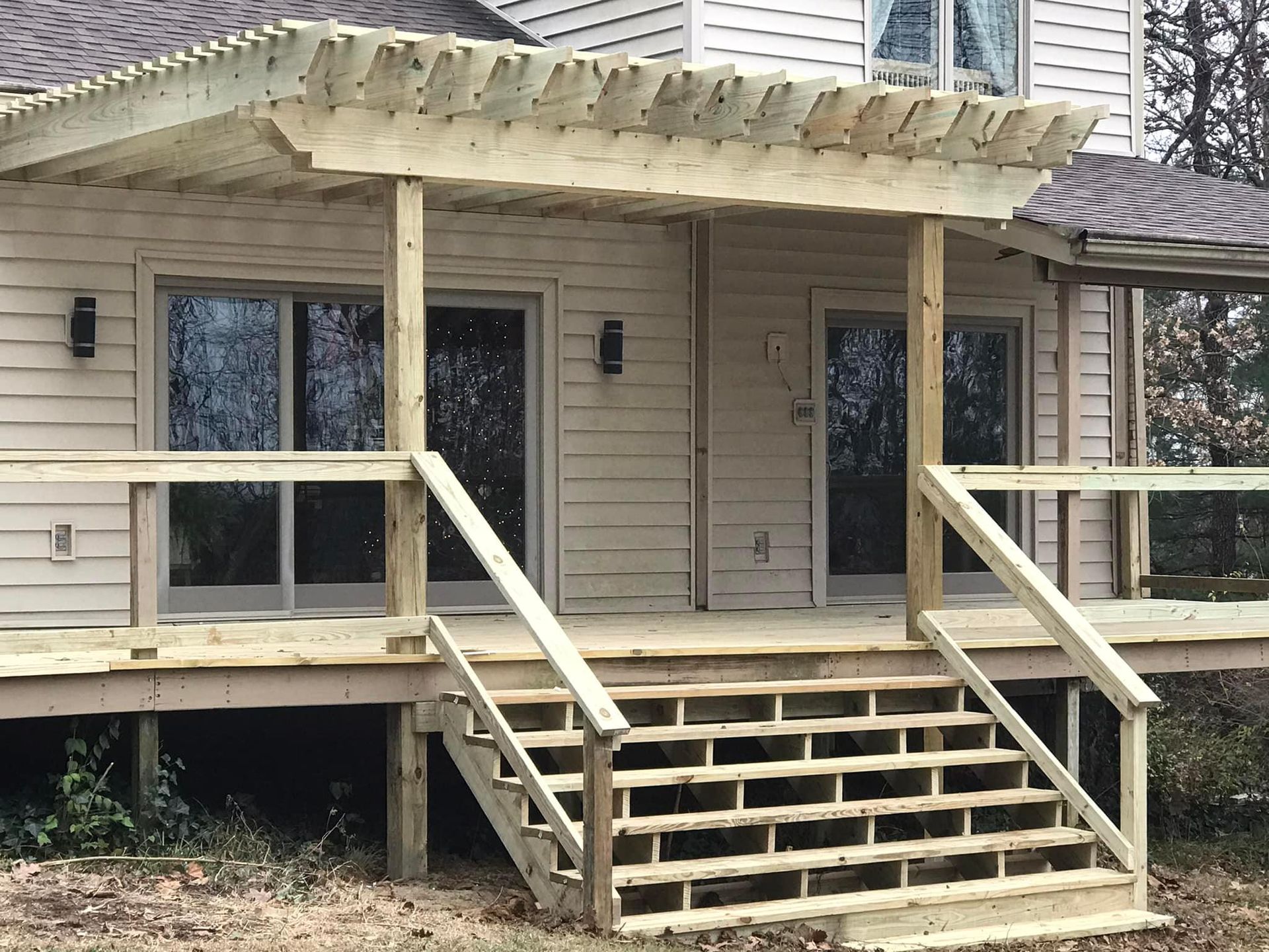 A white house with a wooden deck and stairs