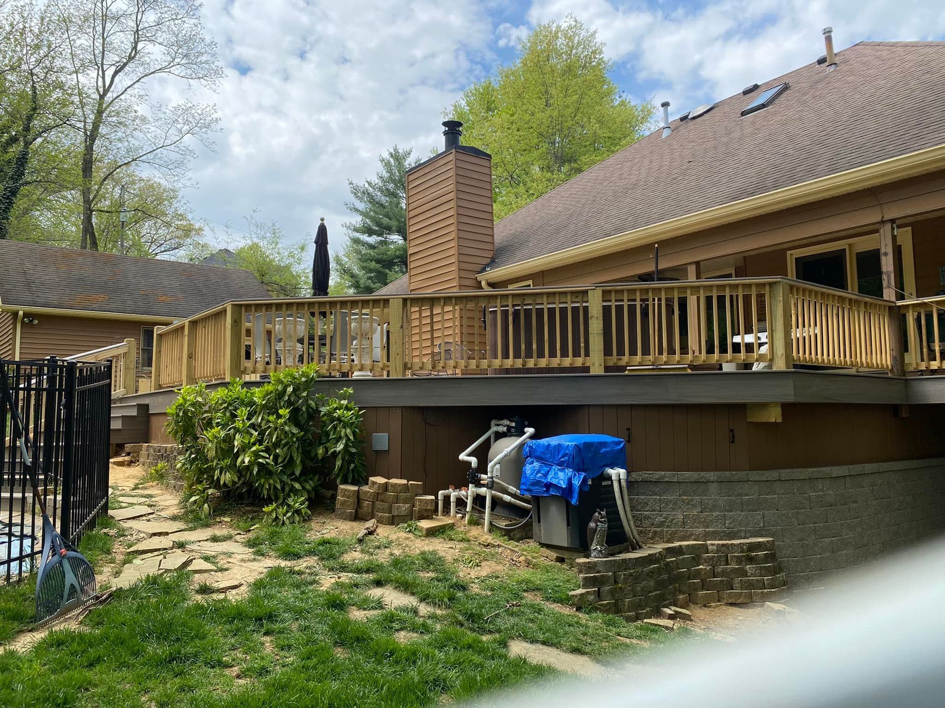 A large wooden deck is sitting on the side of a house.
