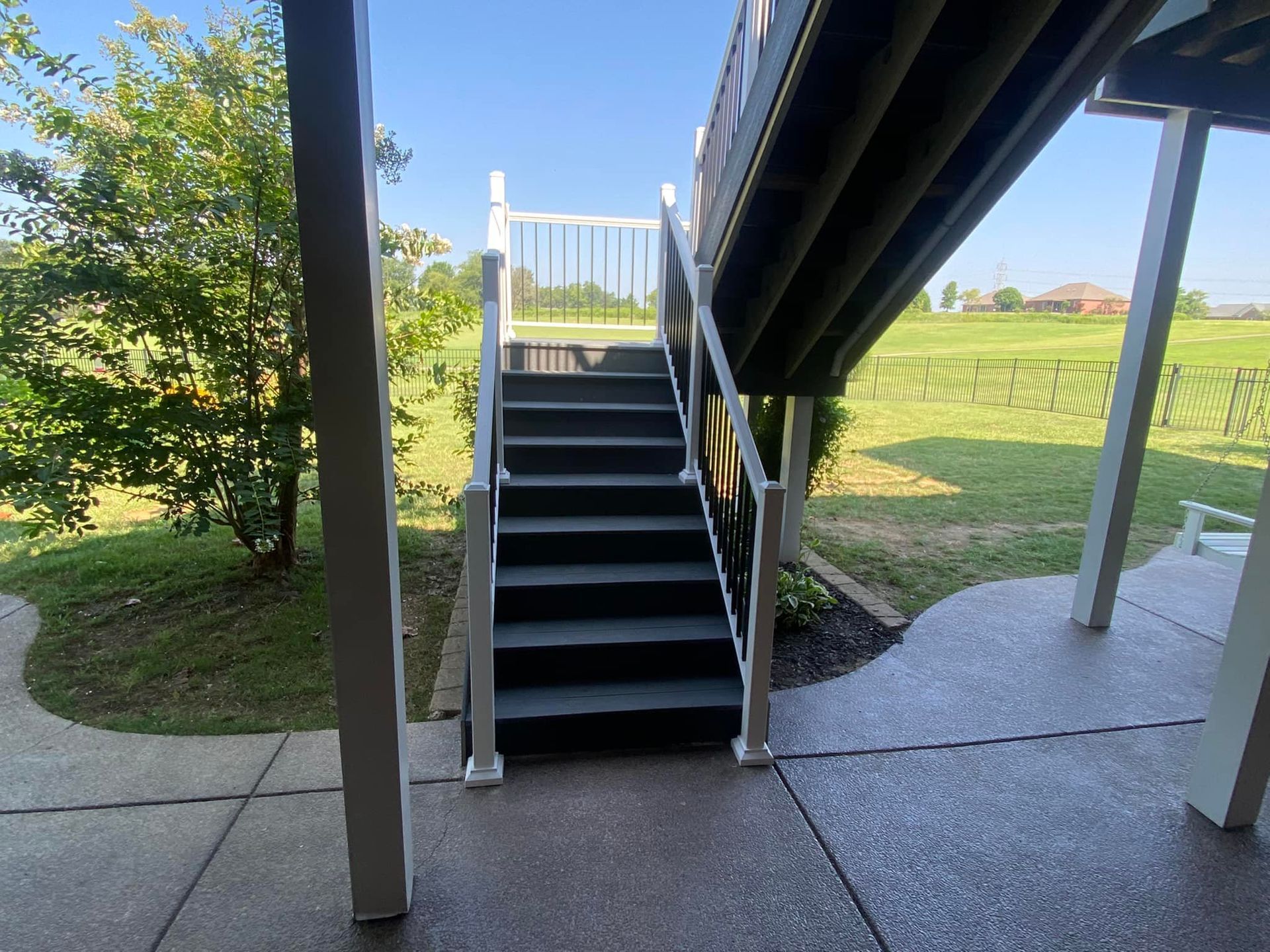 A set of stairs leading up to a deck with a white railing