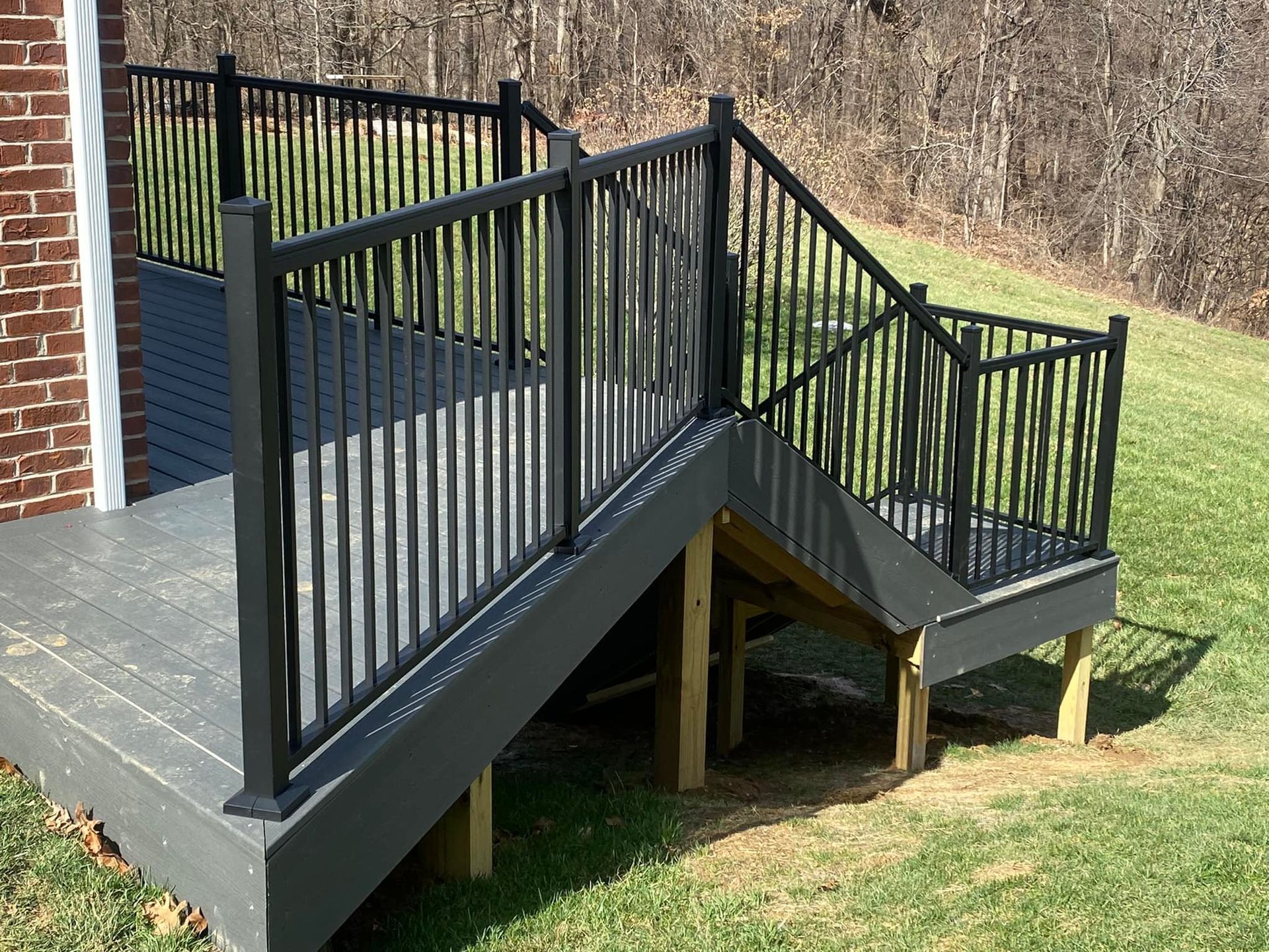 A staircase leading up to a deck with a black railing