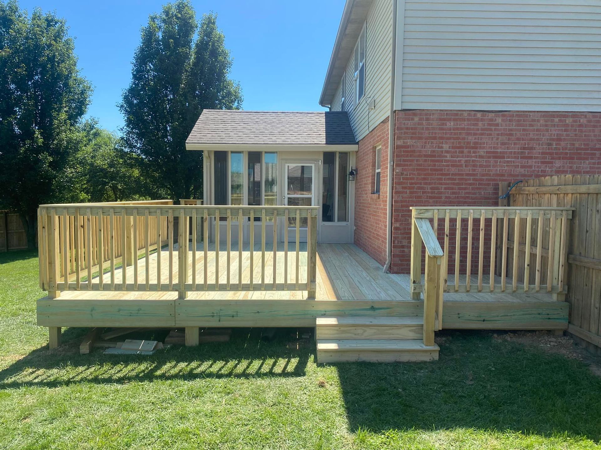 A brick house with a wooden deck in front of it