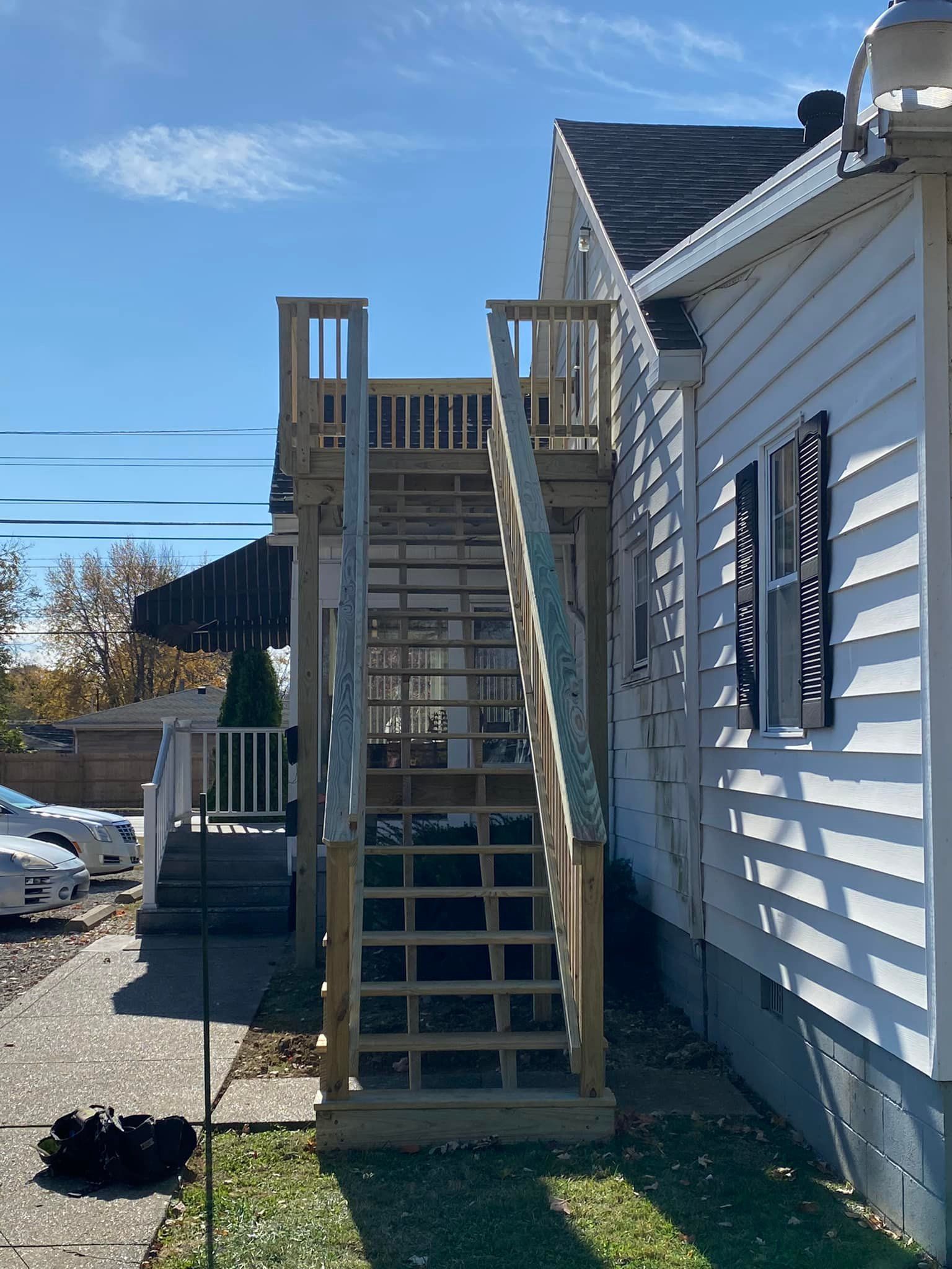 A white house with stairs leading up to the second floor