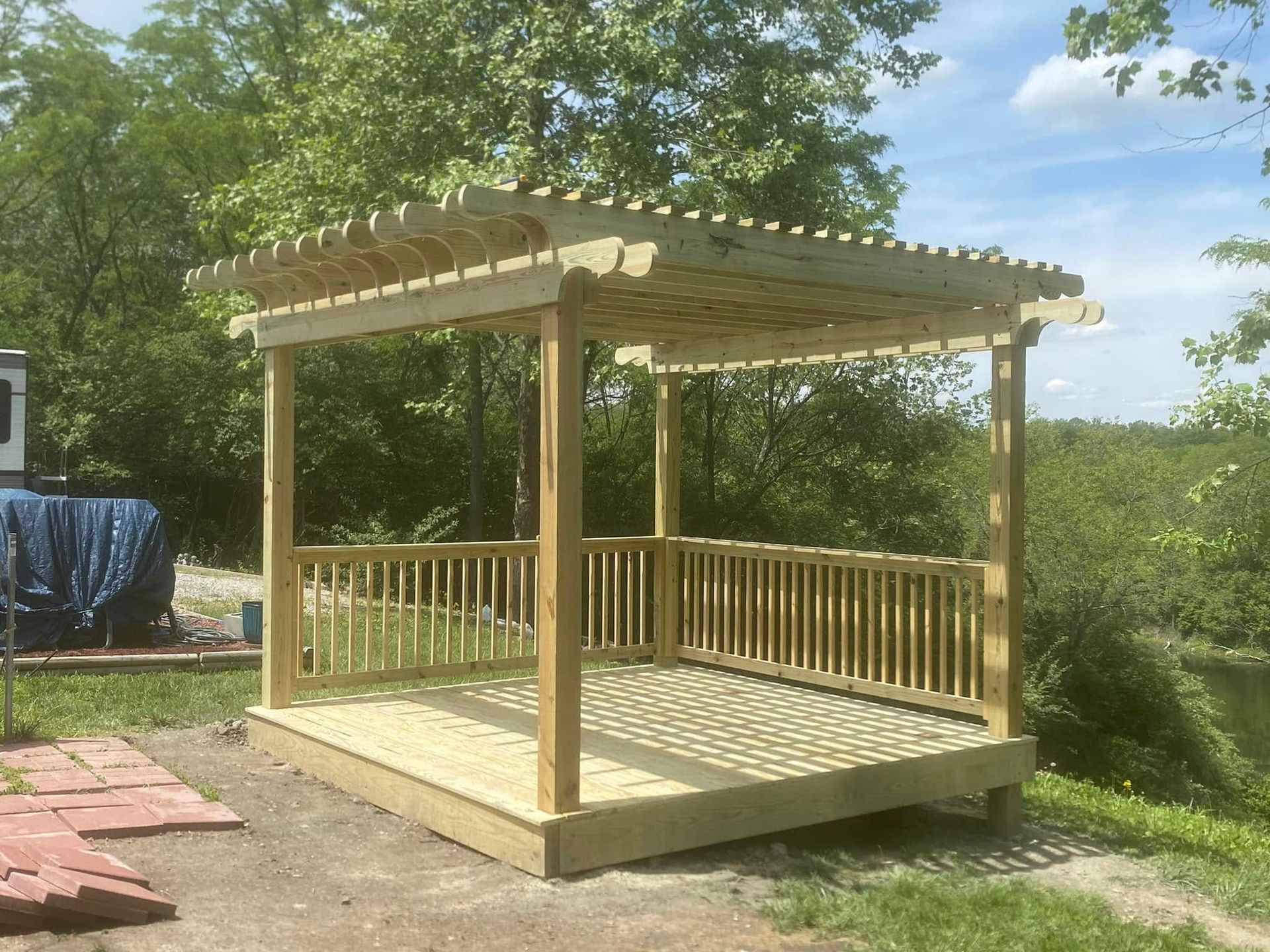A wooden deck with a pergola and railing