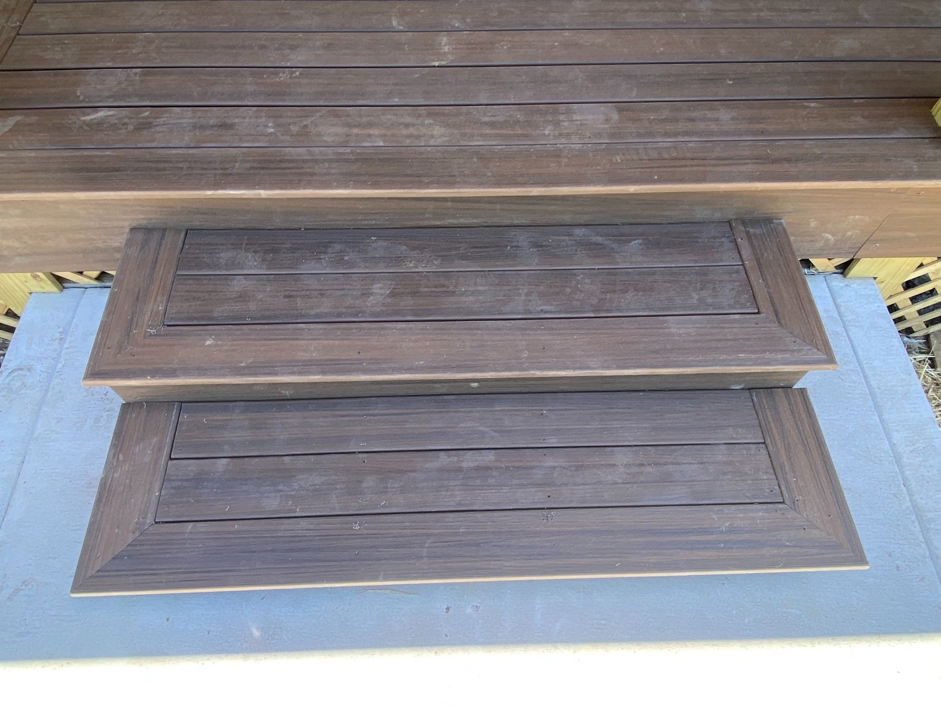 A set of wooden steps leading up to a wooden deck.
