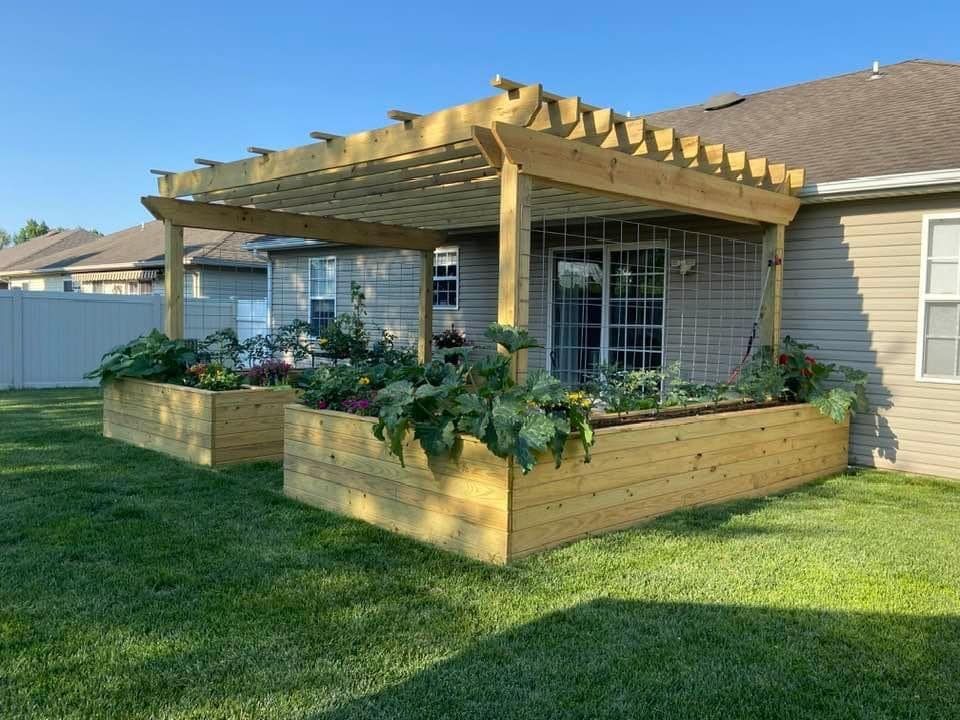 A house with a pergola and planters in the backyard.