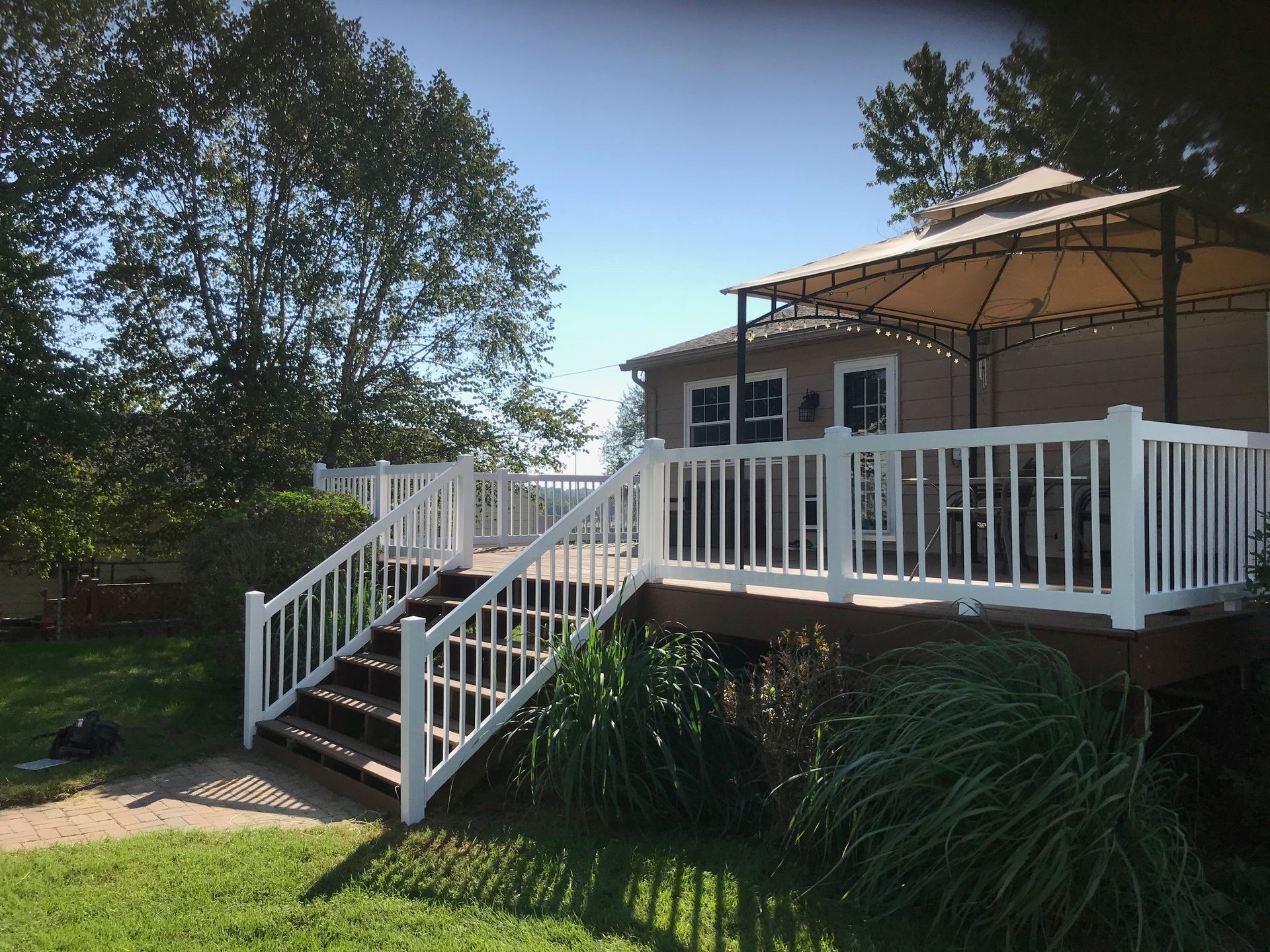 A deck with stairs and a gazebo on top of it