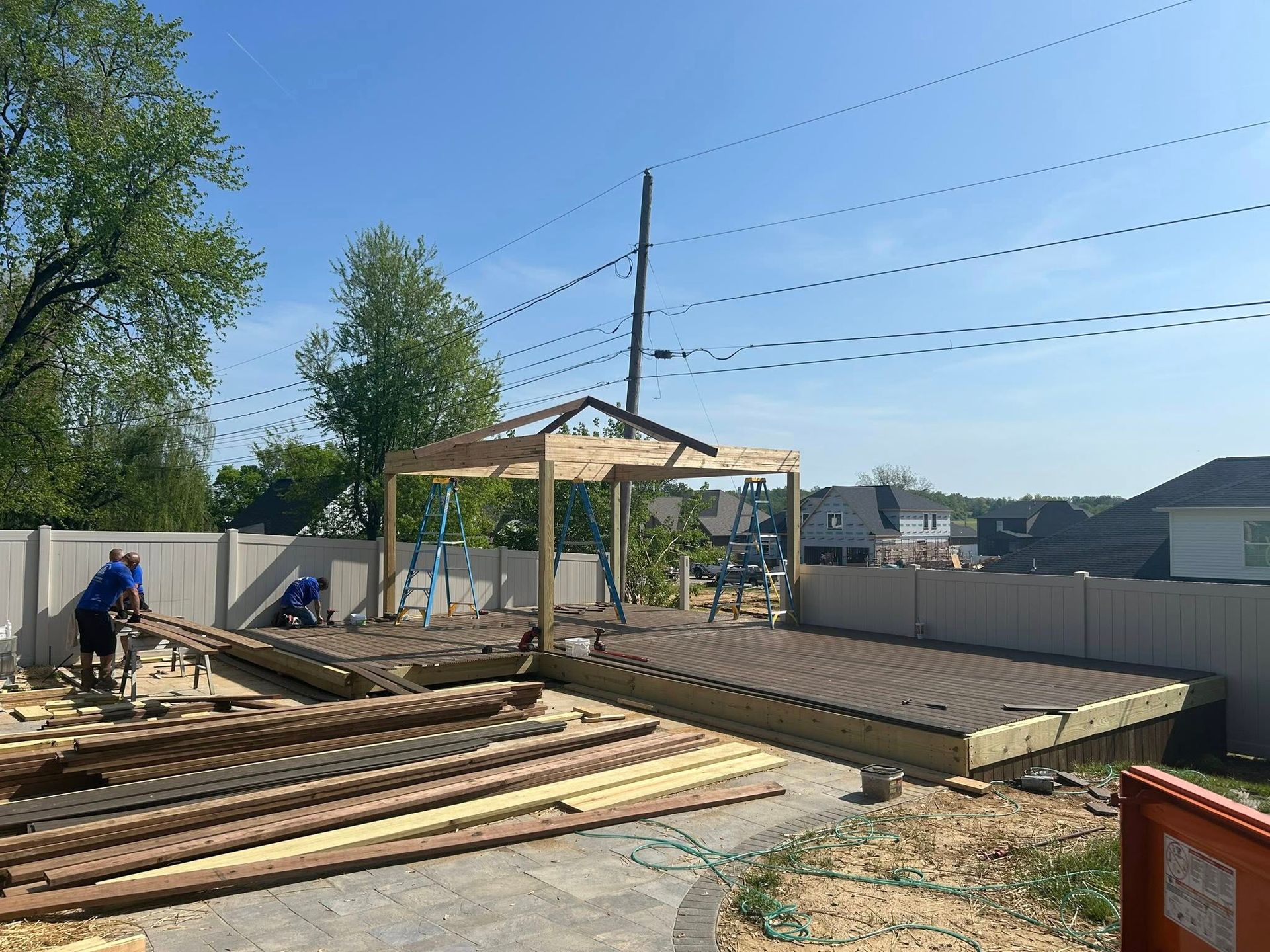 A man is working on a wooden structure in a backyard.