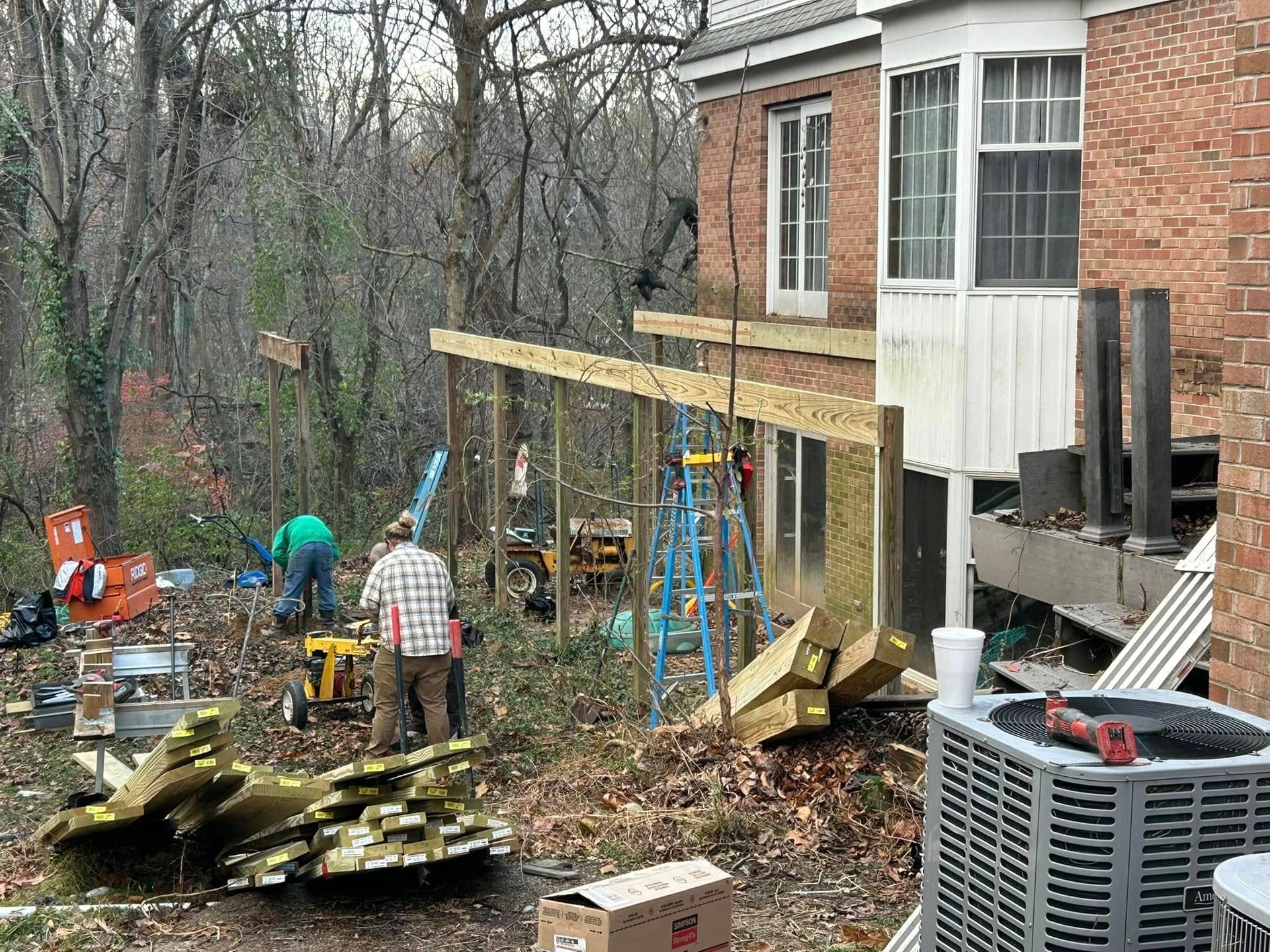 A group of people are working on a house in the woods.