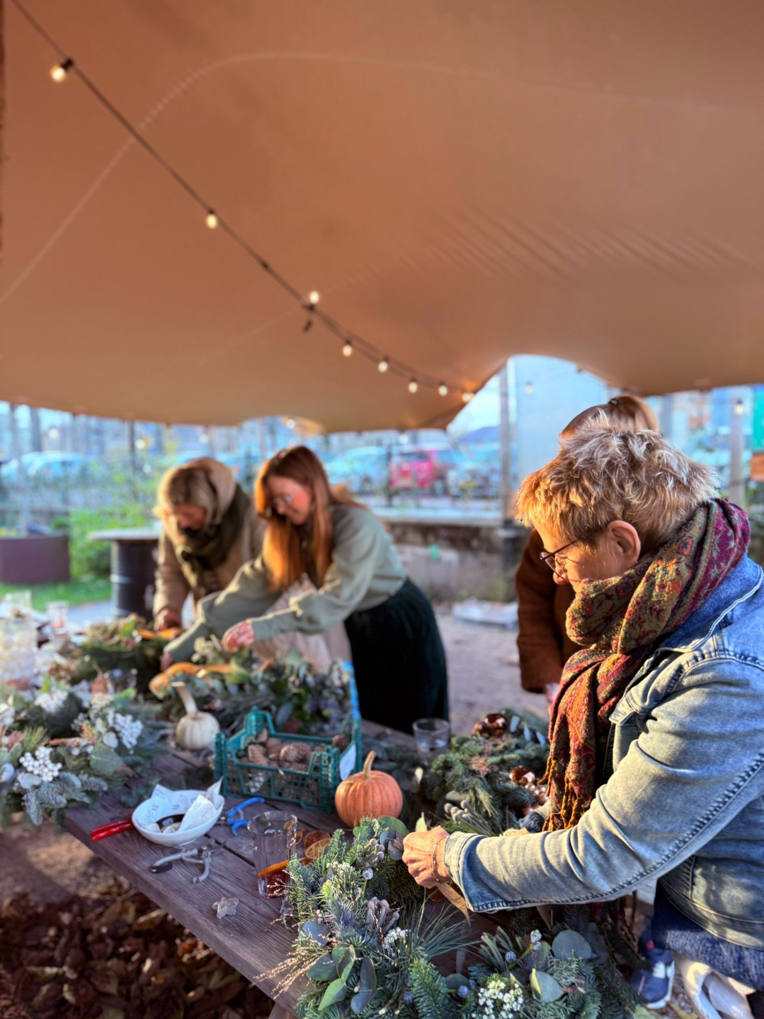 Workshop met een aantal dames die leuk aan het bloemschikken zijn en een krans maken.