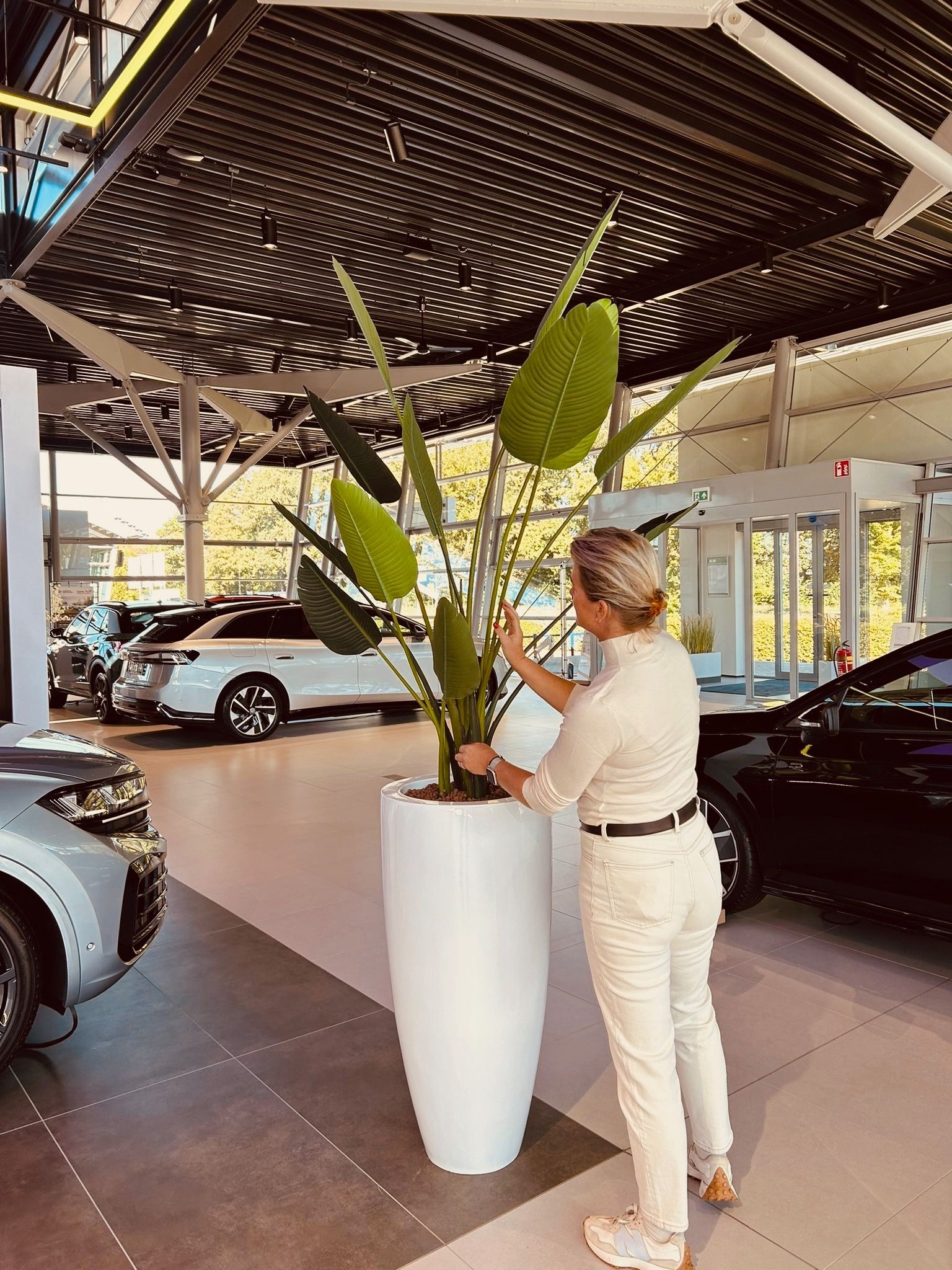 Fleurige zijden bloemen in een vaas met Marlou ernaast bij autobedrijf, huiskes kokkeler in Doetinchem