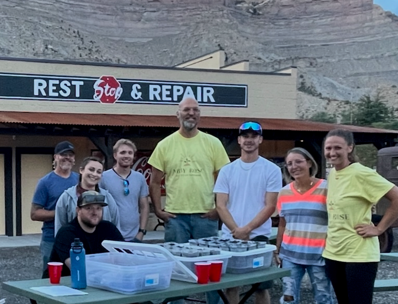Group of people smiling in front of a 
