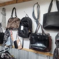 Bags hanging on a pegboard: handbags, backpack, scarves, and accessories.