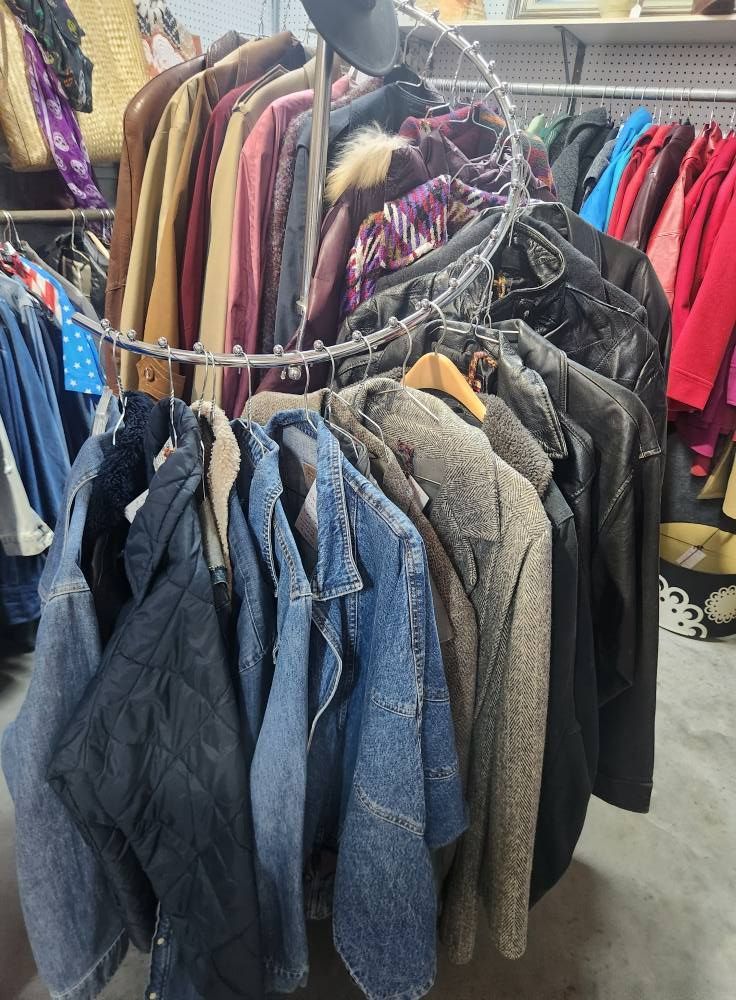 Circular clothing rack displaying various jackets and coats in a store.