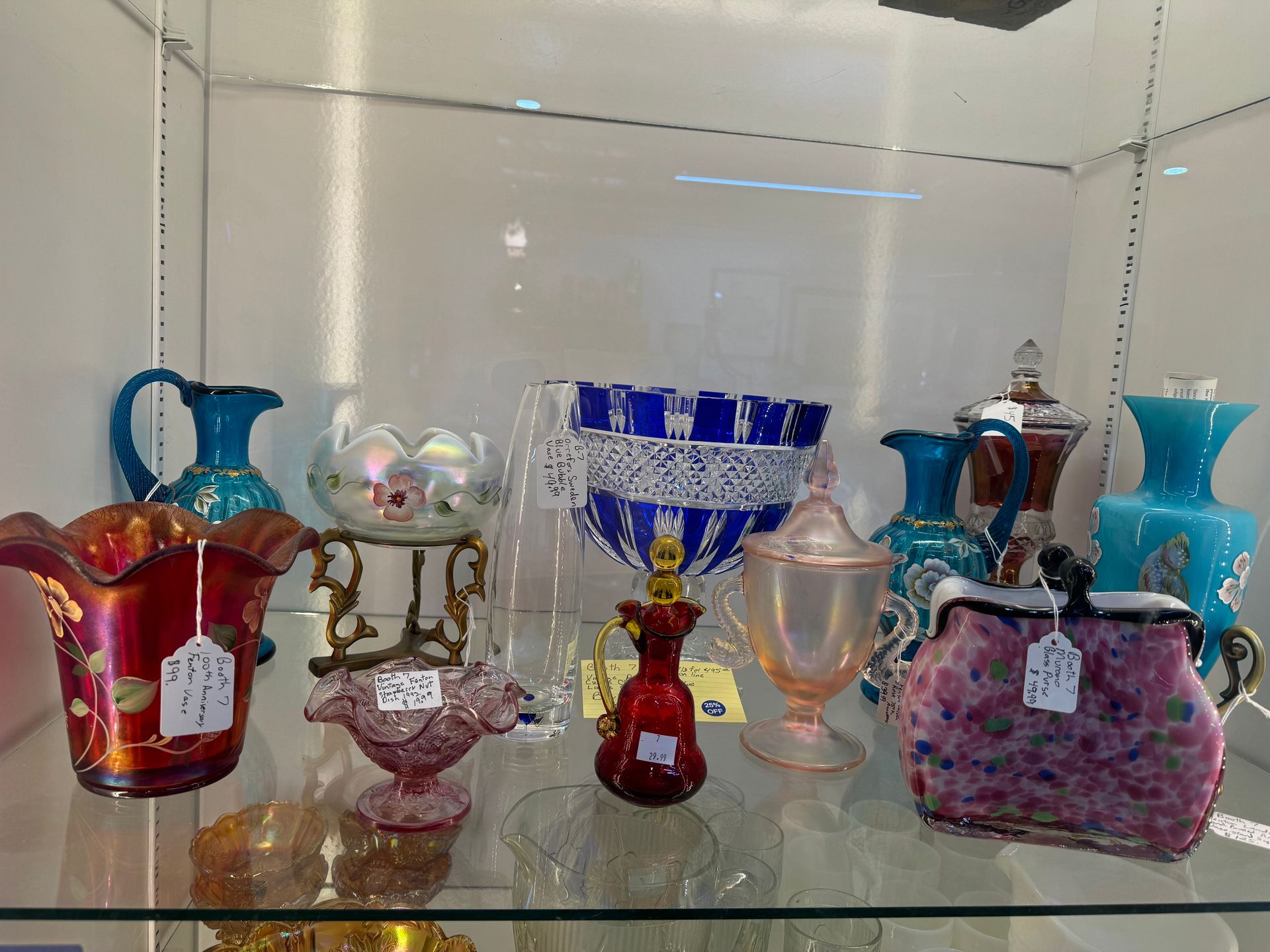 Glassware display case: colorful vases, bowls, and decorative pieces in various shapes and sizes.
