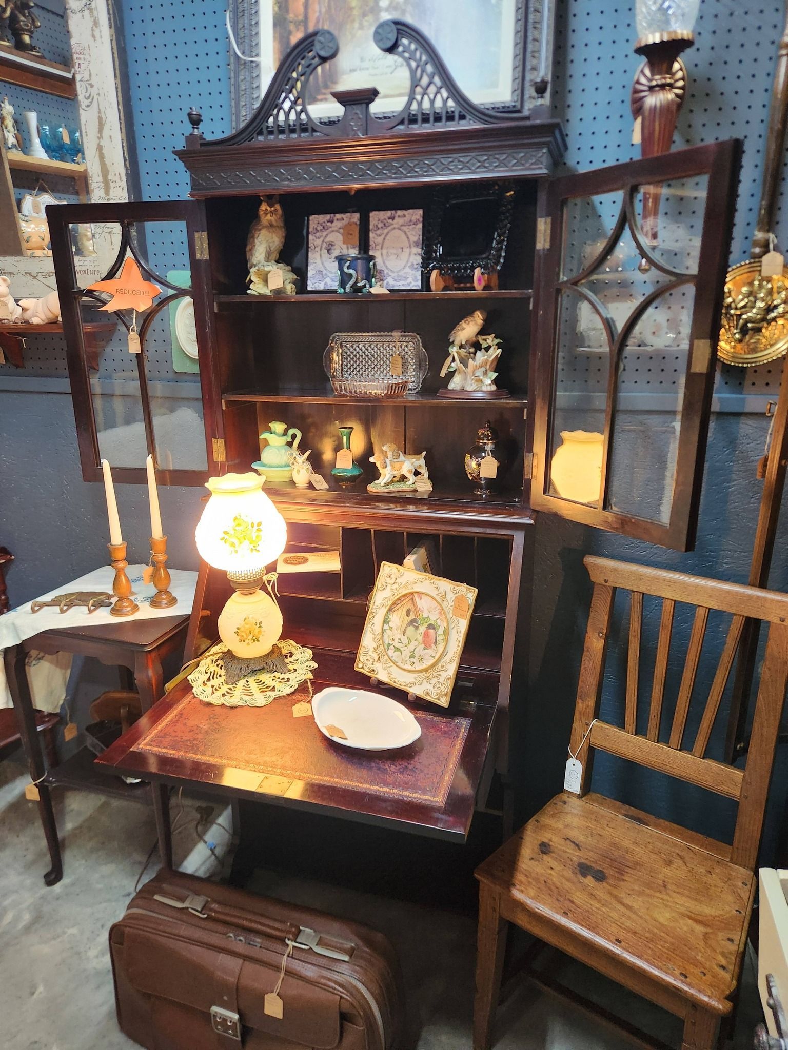 Interior view of an antique shop filled with furniture, decor, and art; neutral lighting.