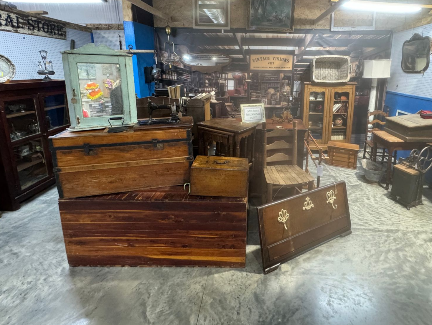 Antique store interior with various wooden furniture items: chests, cabinets, and a table.