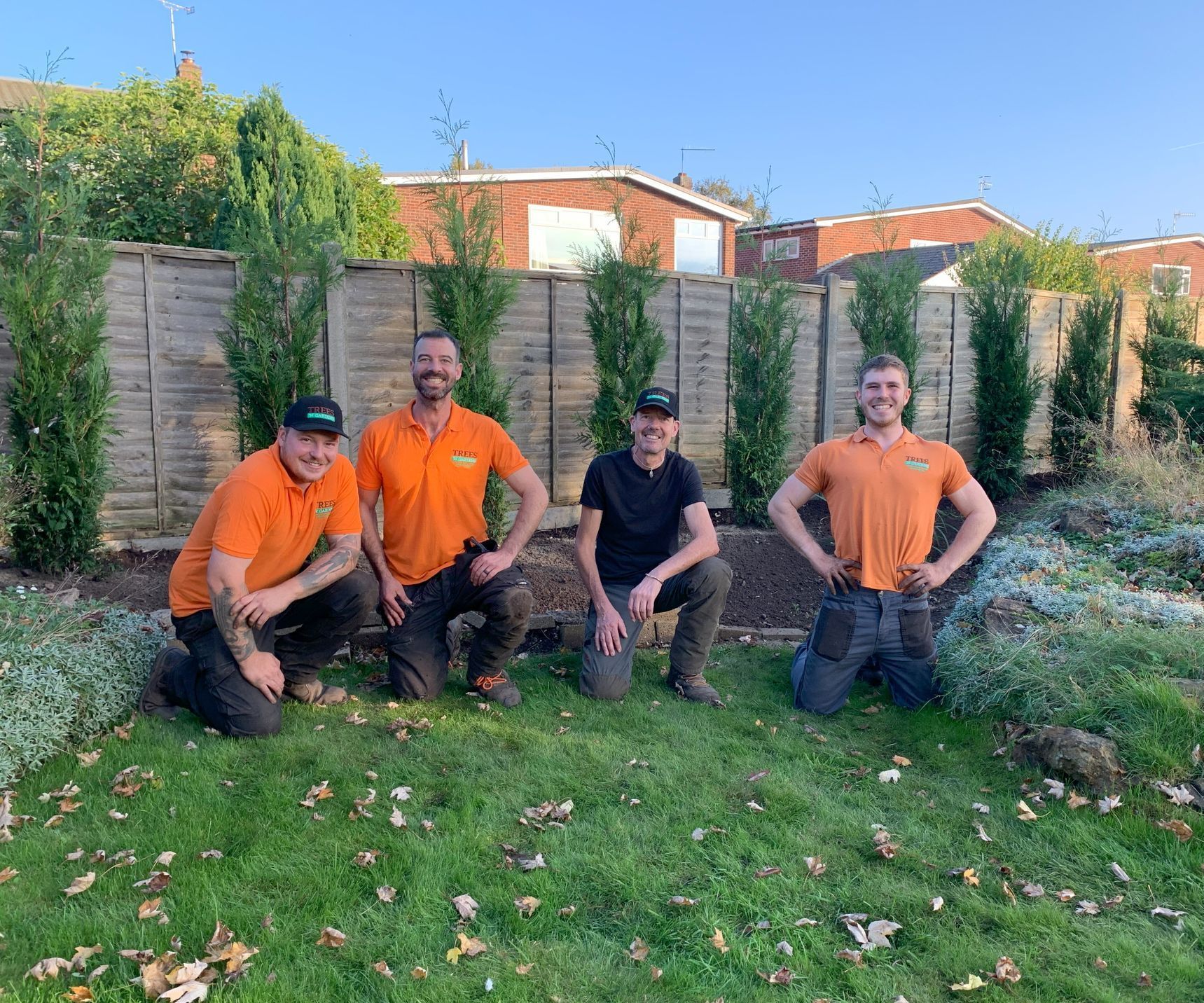 A group of men are posing for a picture in a garden.