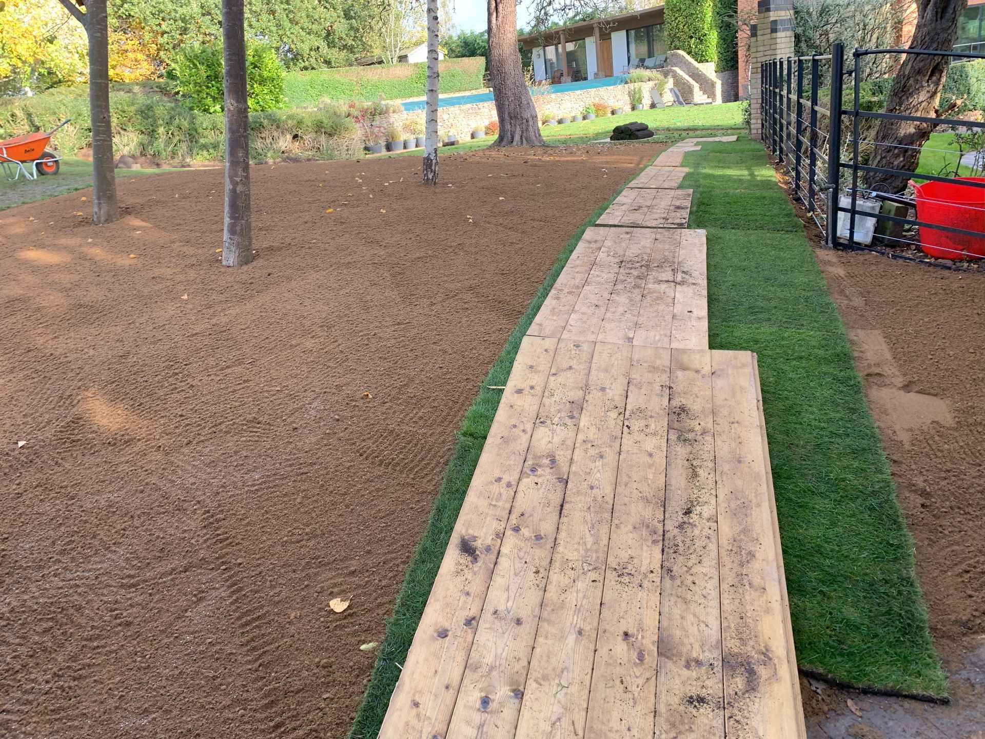 A wooden walkway is being built in a backyard.
