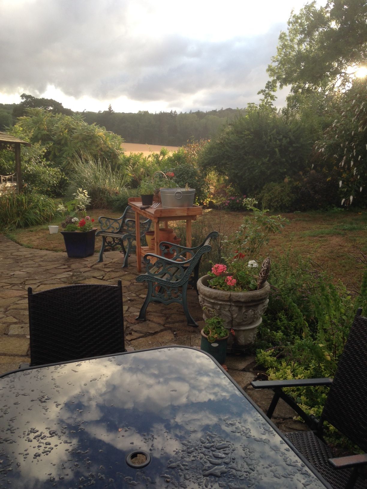 A table and chairs on a patio with a view of a field