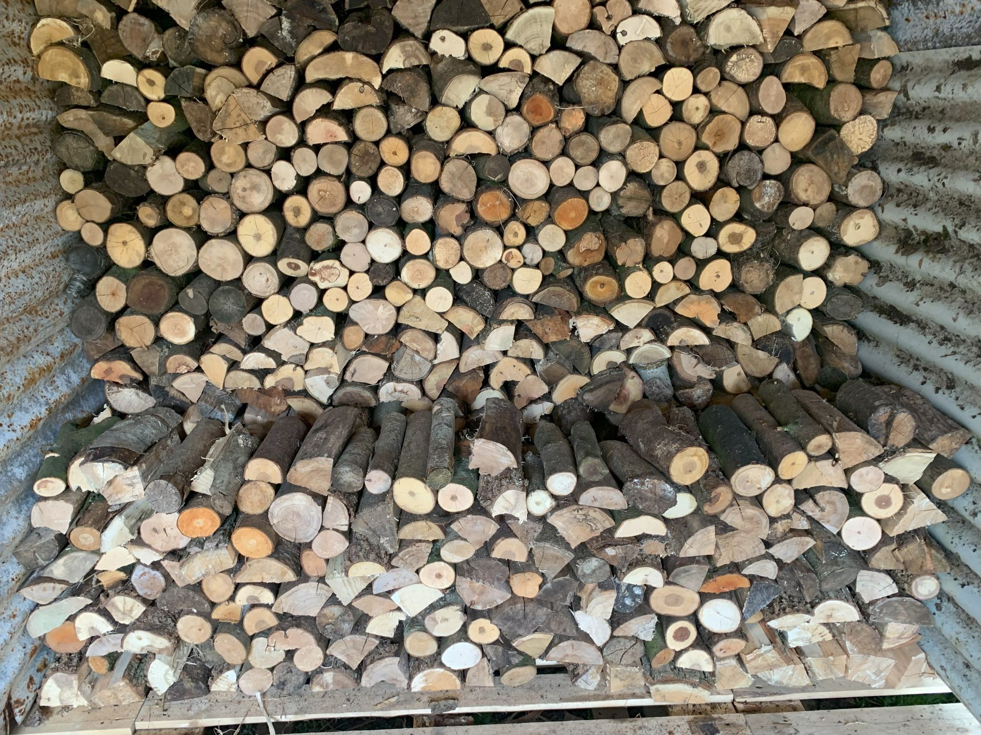 A pile of logs stacked on top of each other in a metal container.