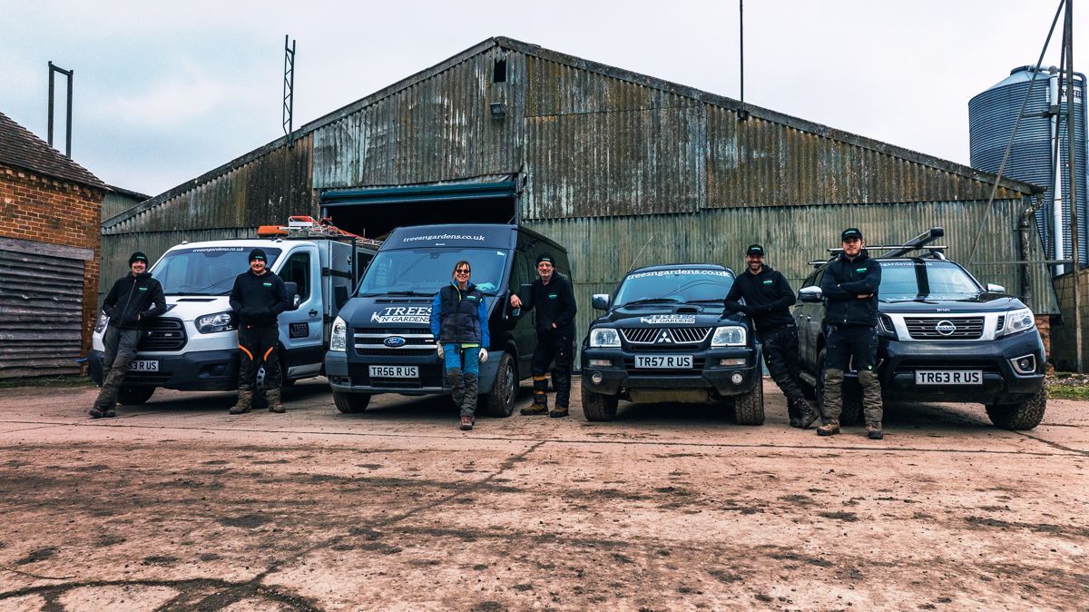 A group of people standing in front of a row of vehicles.