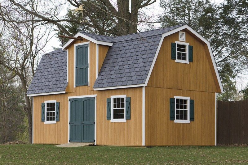 2 story dutch barn with brown siding and green doors and shutters