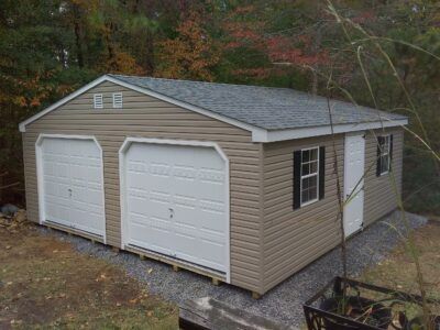 double wide garage with tan siding and white doors 