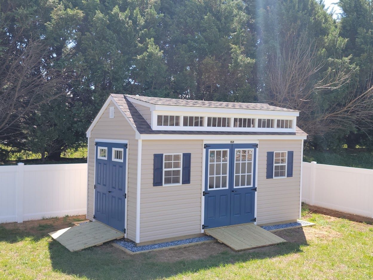 white dormer shed with blue doors and two ramps