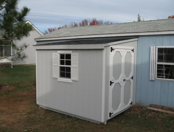 lean-to shed with gray siding and white trim