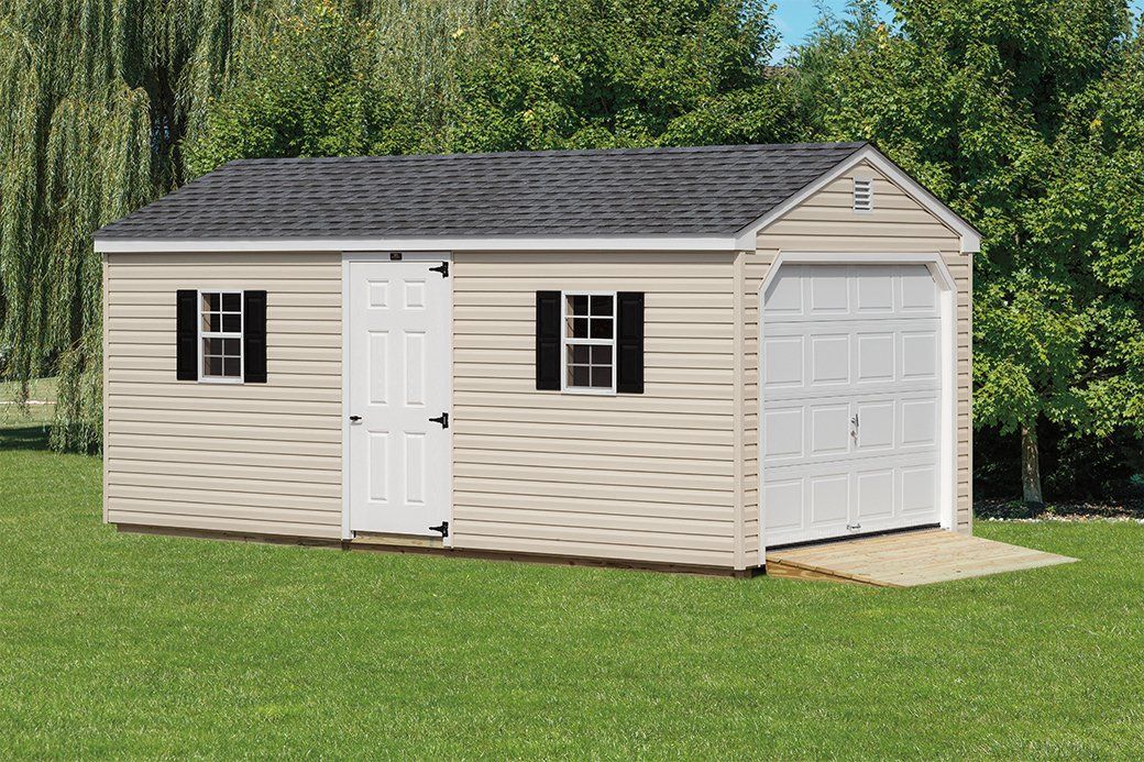 Tan single-car garage with a white garage door, a white single door, 2 windows with black shutters, and a dark gray roof