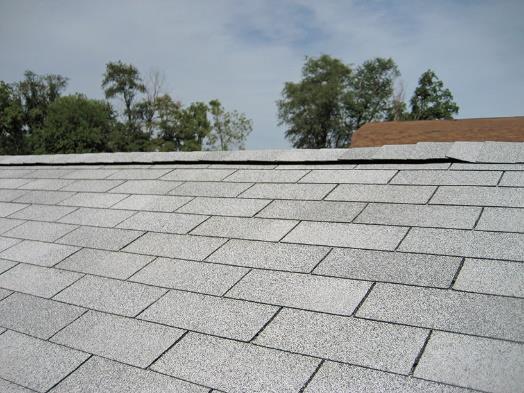 Close up of a gray shed roof with a ridge vent