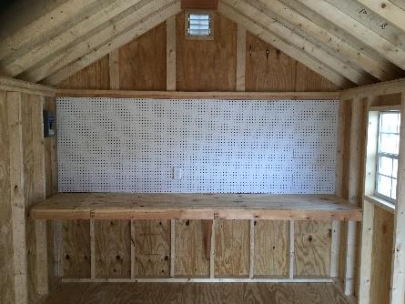 Interior of a shed with a pegboard and workbench