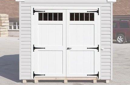 Close up of a set of white double doors with transom windows