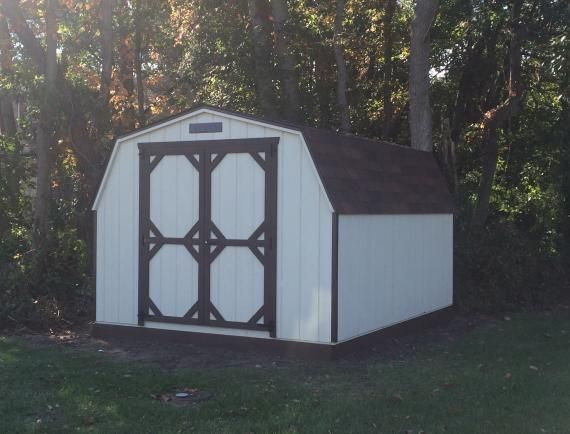 mini barn shed with white siding and black trim