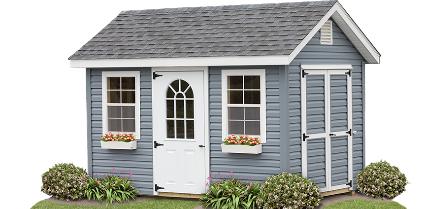 Gray-blue shed with white trim, windows with flower boxes, a white door with arch windows, and a gray roof.