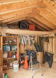inside of a shed with shelves and a loft storing outdoor equipment 