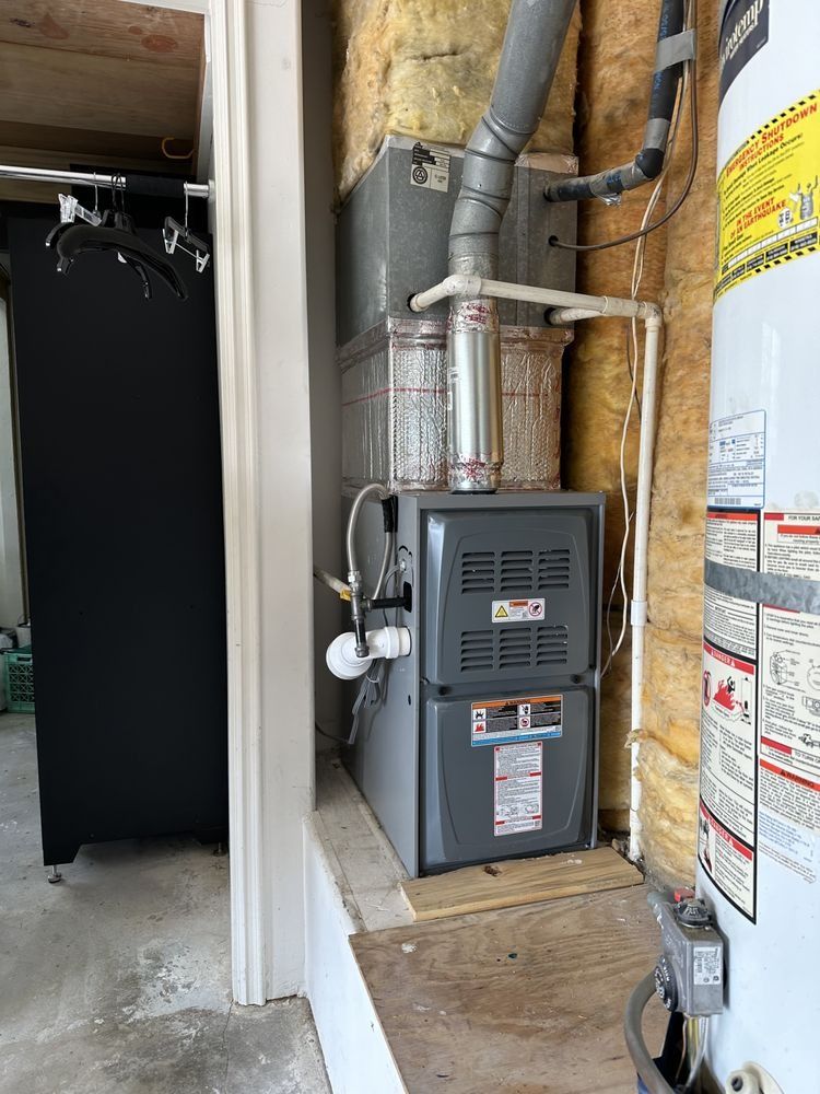 Furnace and water heater in a utility room with insulation.