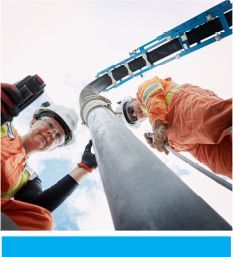 Two employees use a boom for hydro excavation