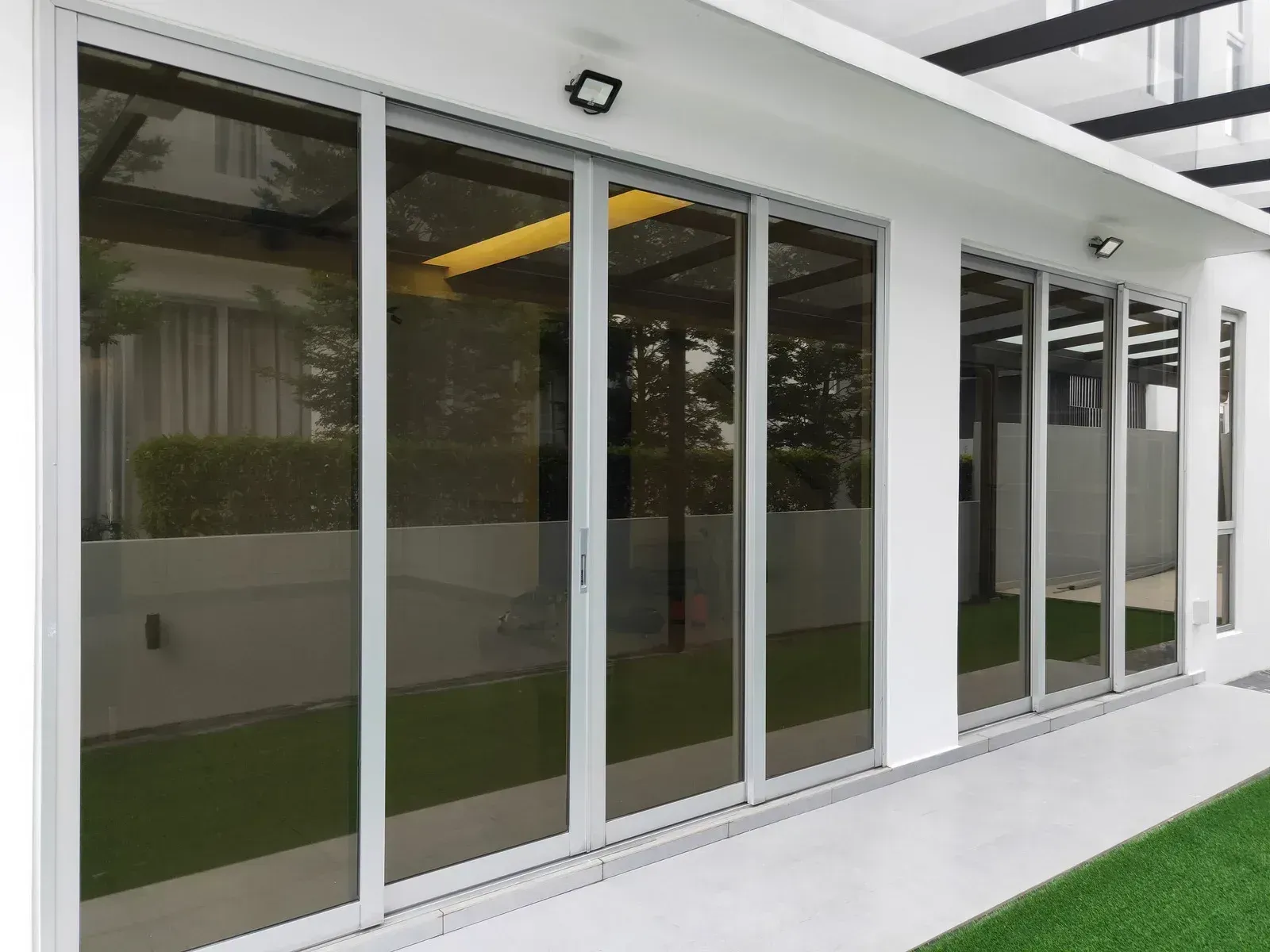 A white building with a lot of windows and sliding glass doors.